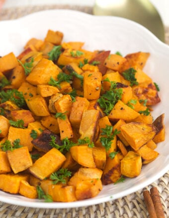 Herbs garnish a serving of roasted sweet potatoes.