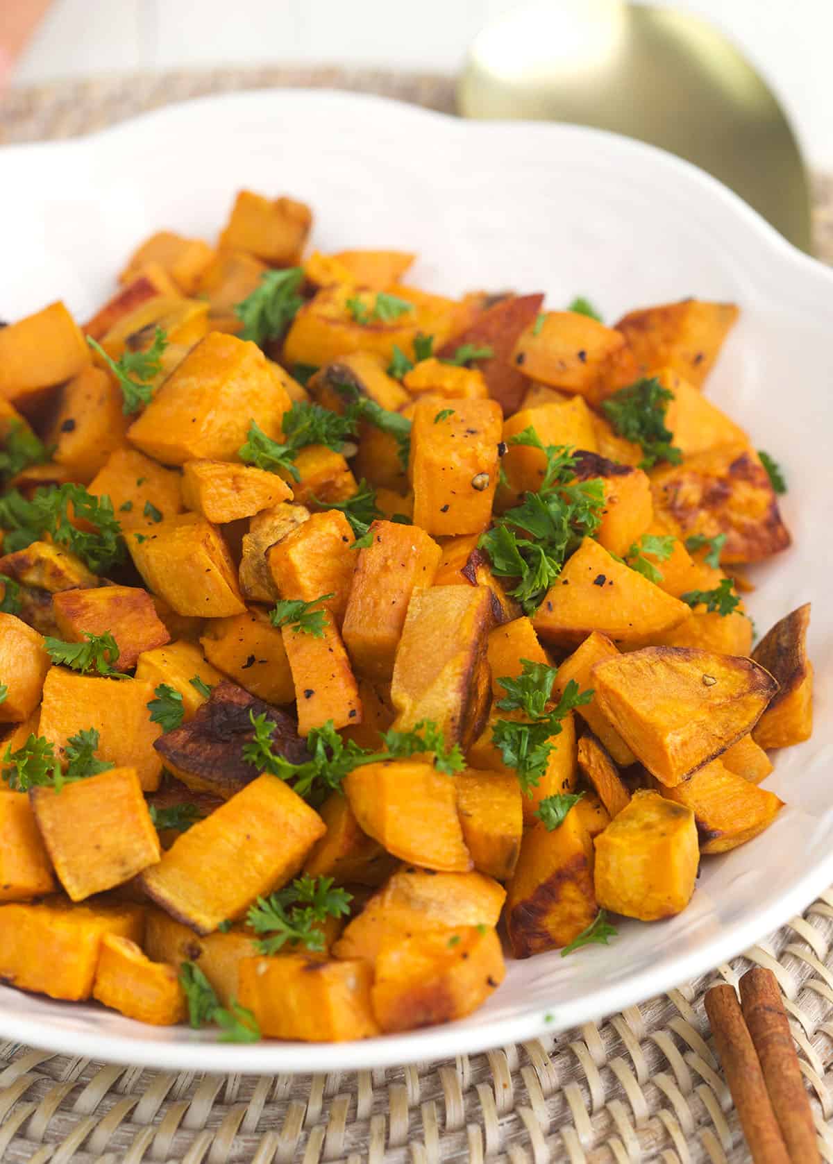 Herbs garnish a serving of roasted sweet potatoes.