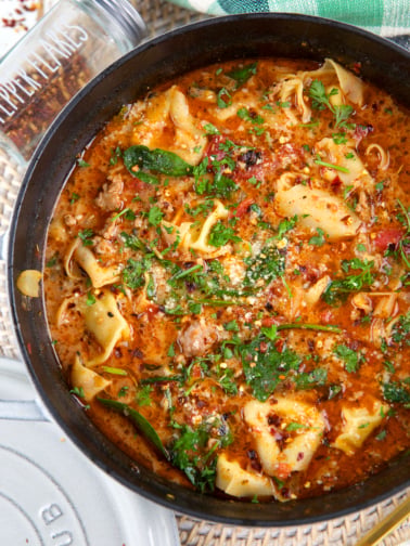A black pot is filled with sausage tortellini soup.