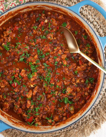 A big serving spoon is placed in a pot of chili.