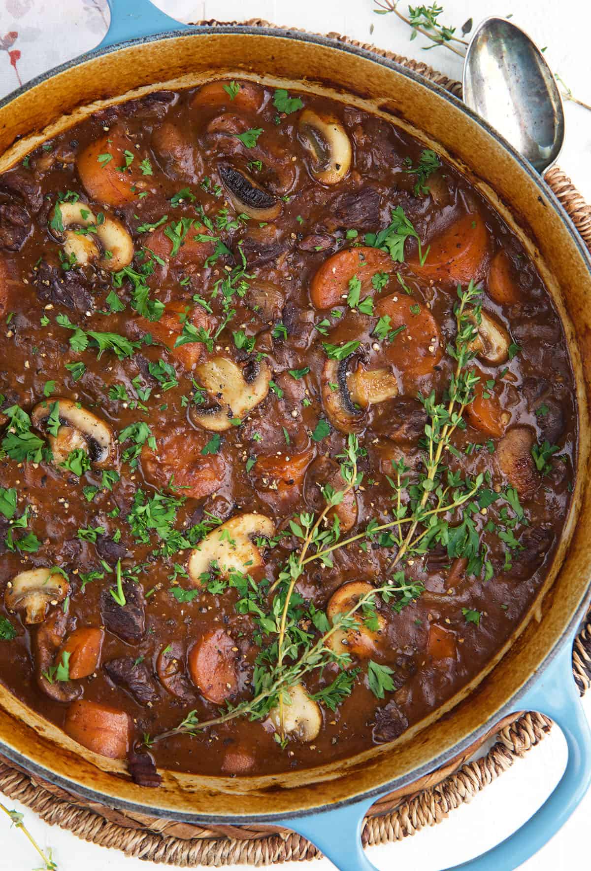 A dutch oven is filled with cooked beef bourguignon. 