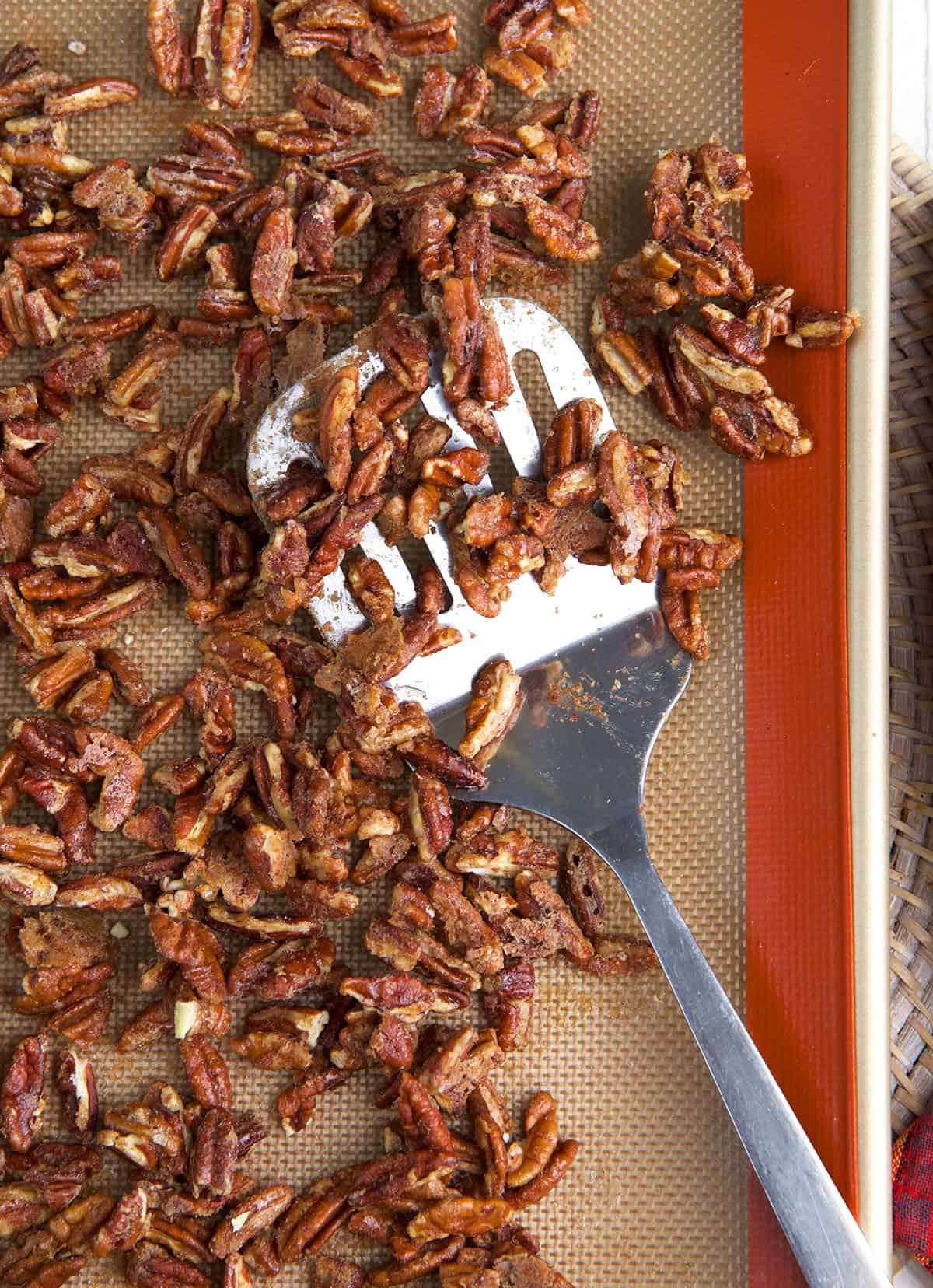 Candied pecans have been roasted on a baking sheet.