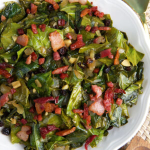 A large white bowl is filled with cooked collard greens.