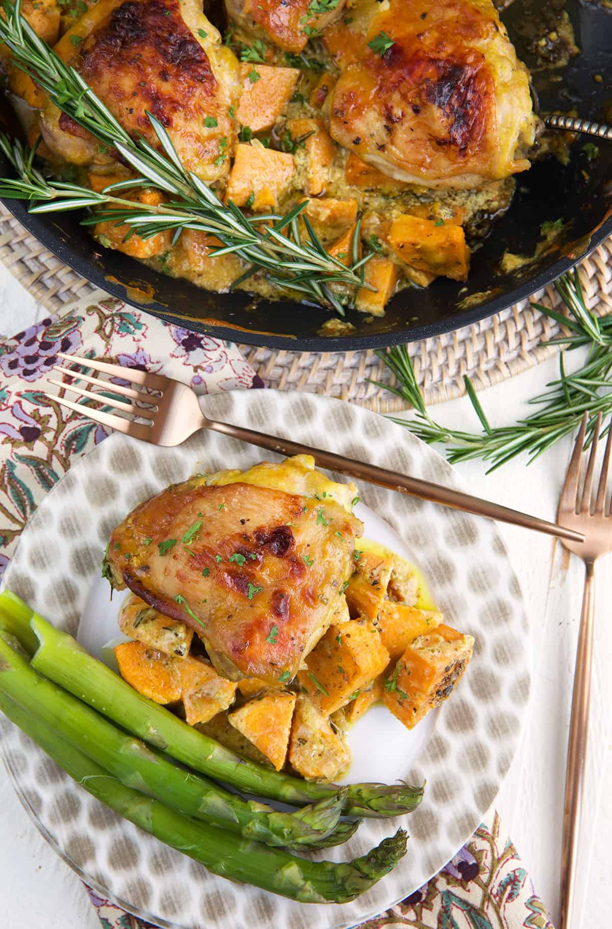 A plate is topped with chicken, sweet potatoes and asparagus. 