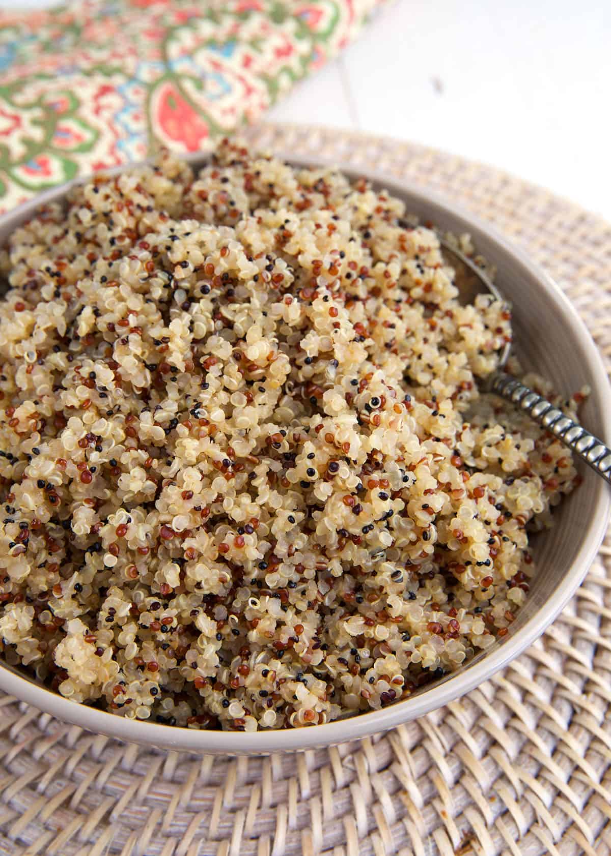 A spoon is placed in a bowl filled with quinoa. 