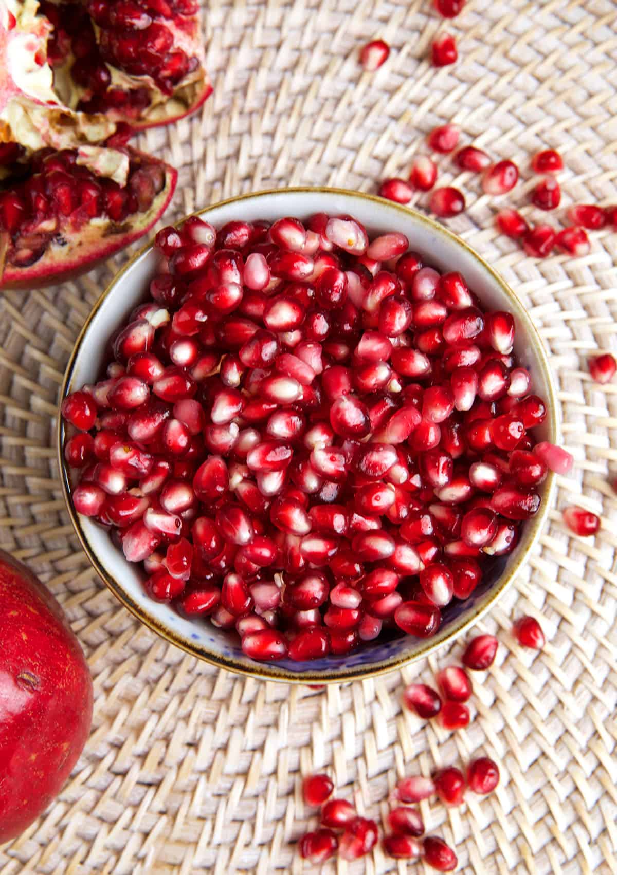 A white bowl is filled with pomegranate arils. 