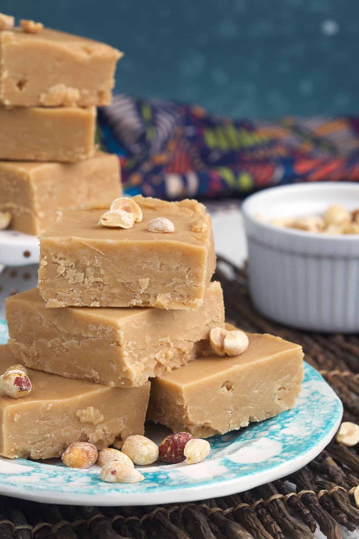 A stack of peanut butter fudge is placed on a blue plate.