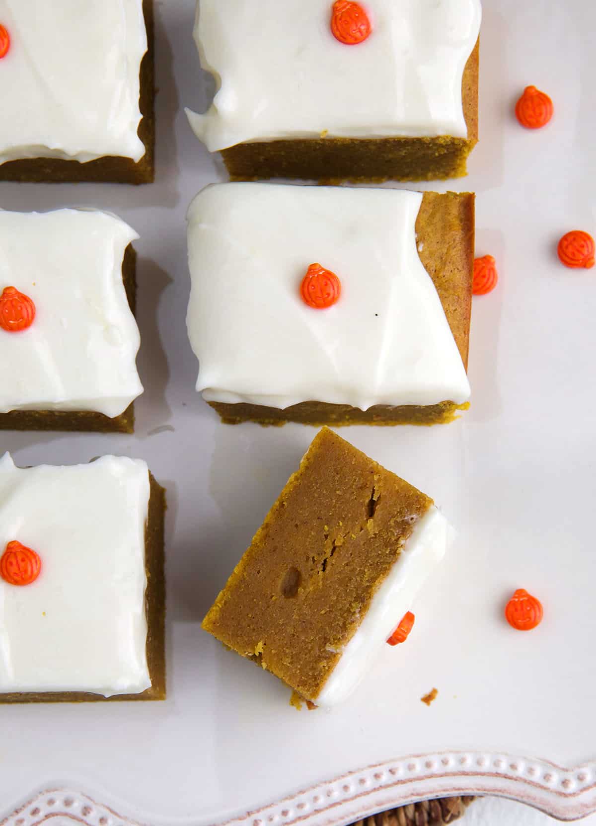 A single pumpkin bar has been flipped on its side to reveal a cooked through center. 