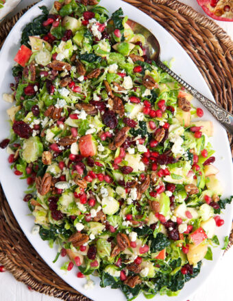 An oval shaped serving plate is topped with brussels sprout salad.