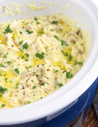 A crockpot is filled with mashed potatoes.
