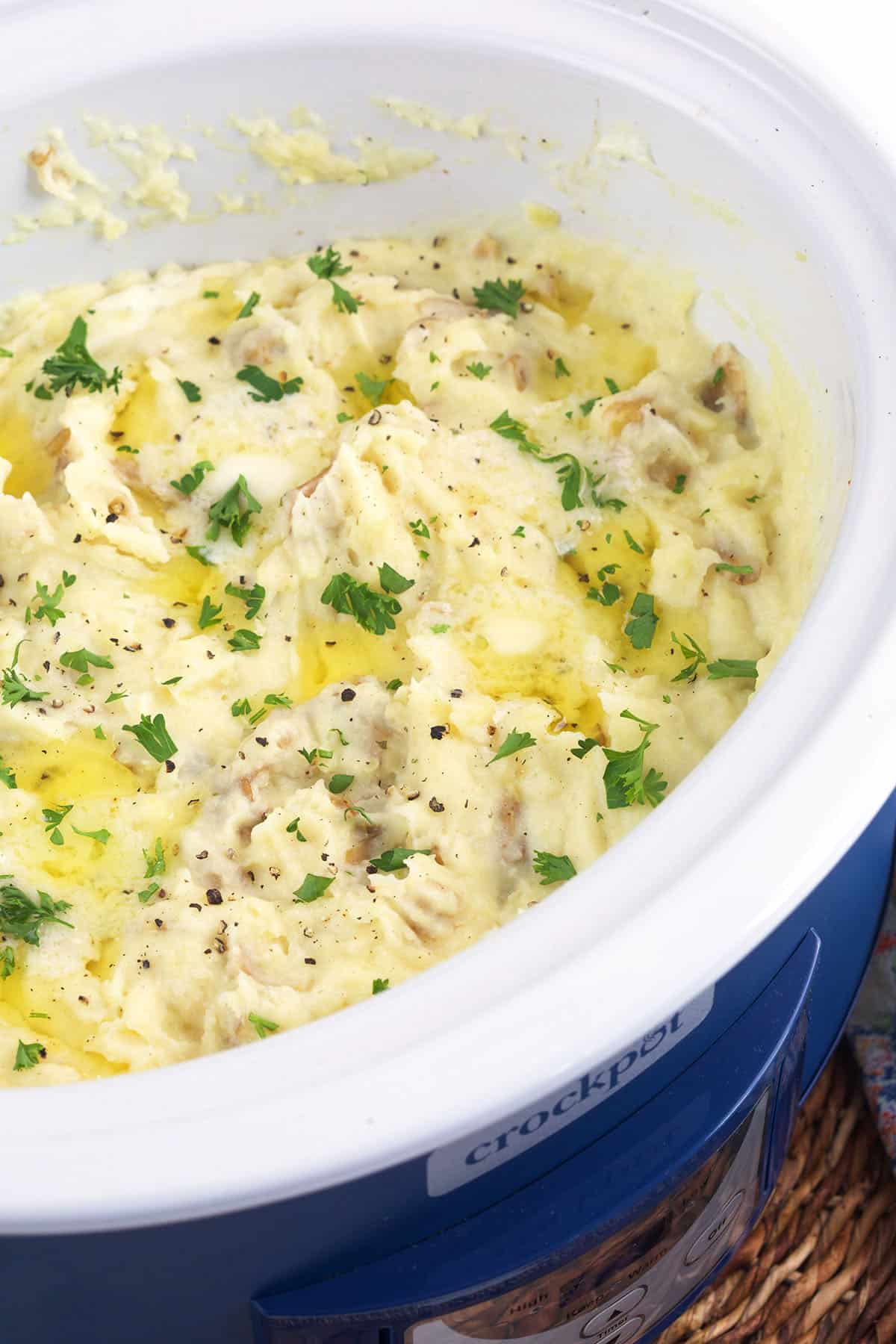 A crockpot is filled with mashed potatoes. 