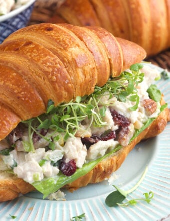 A croissant has been turned into a sandwich with microgreens and turkey salad.