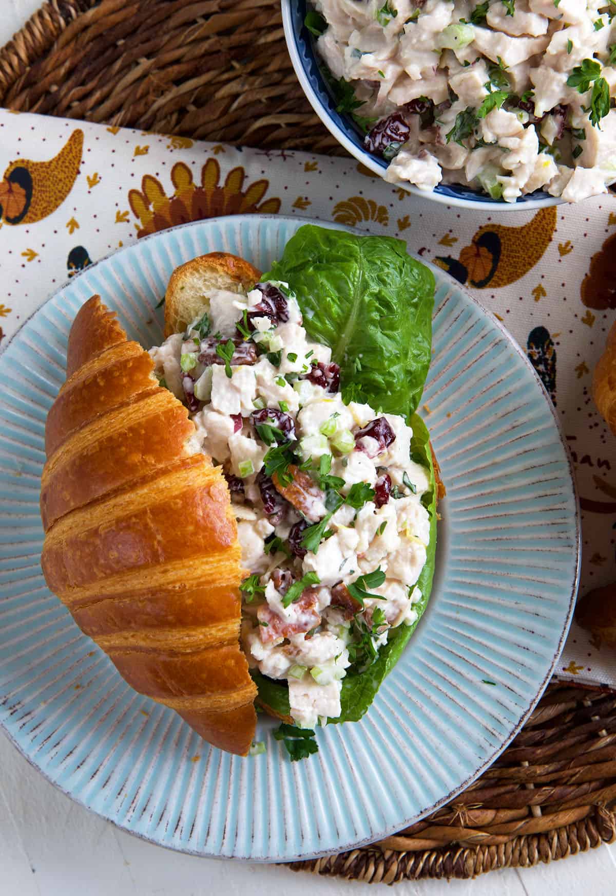 A croissant is stuffed with lettuce and turkey salad. 