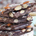 A stack of almond bark pieces is placed on a small cake stand.