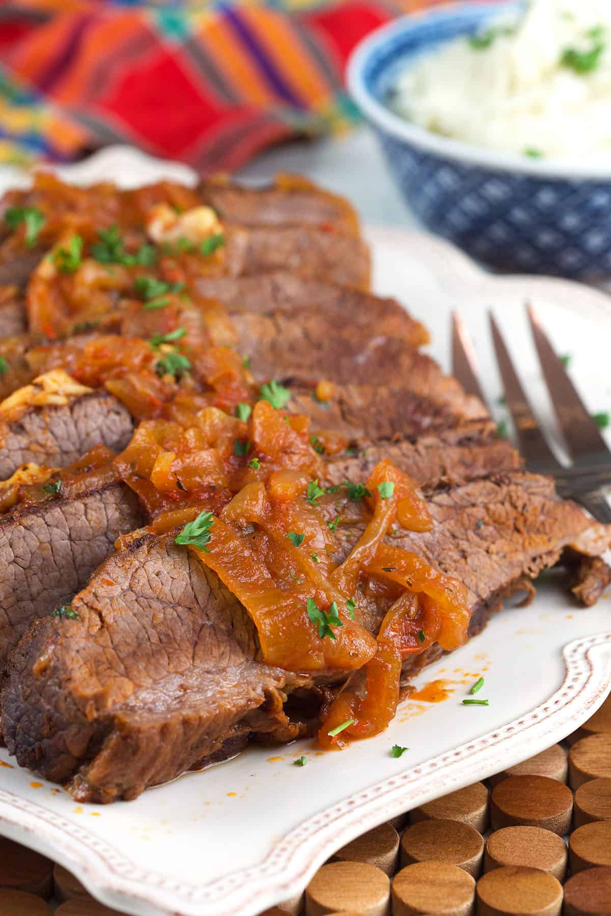 Caramelized onions are spread across the top of sliced brisket. 