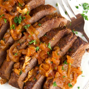 Caramelized onions are spread across the top of sliced beef brisket.