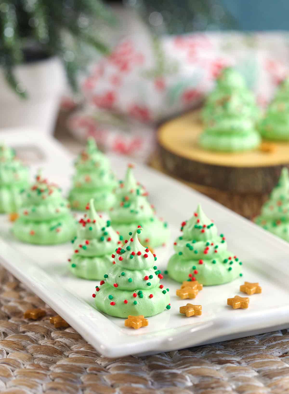 A batch of meringue tree cookies are placed on a white serving plate. 