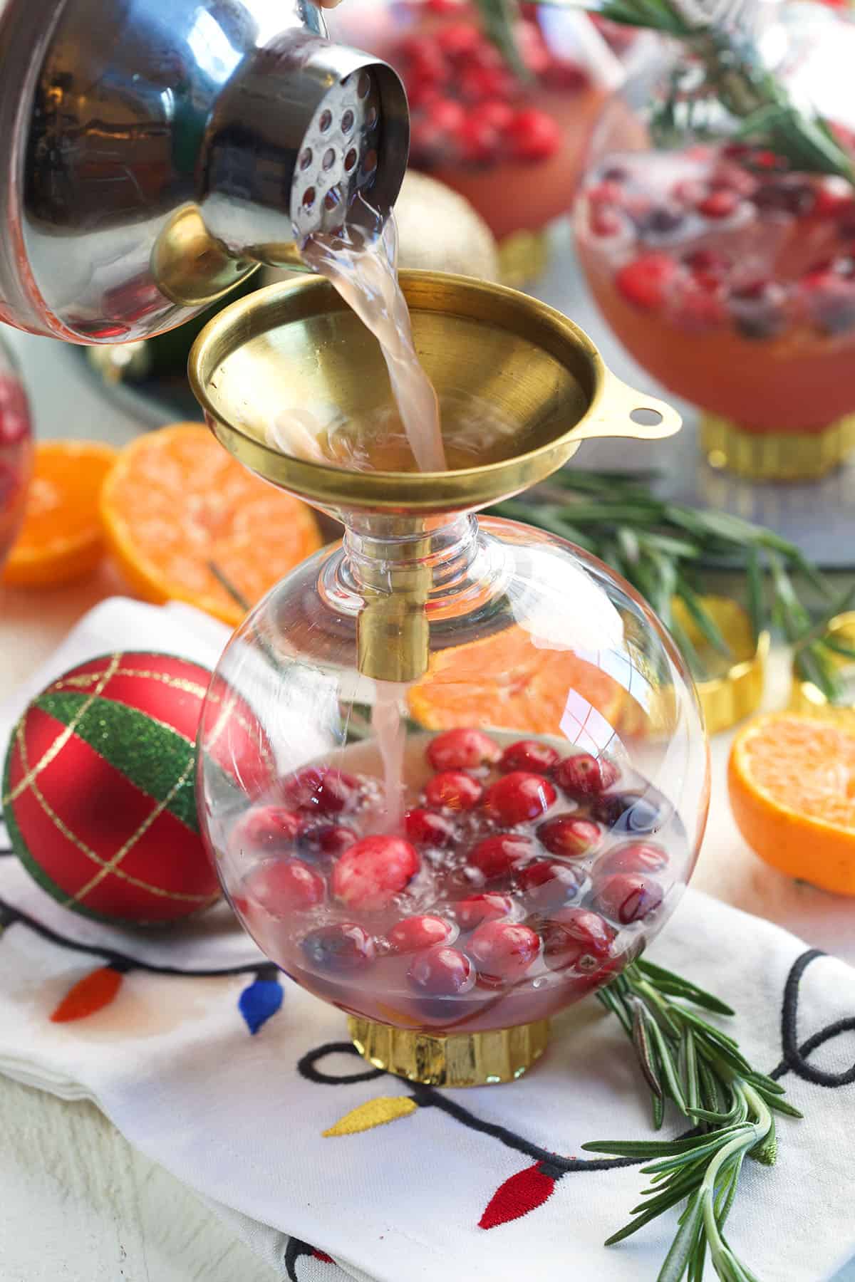 A cocktail is being poured into an ornament. 