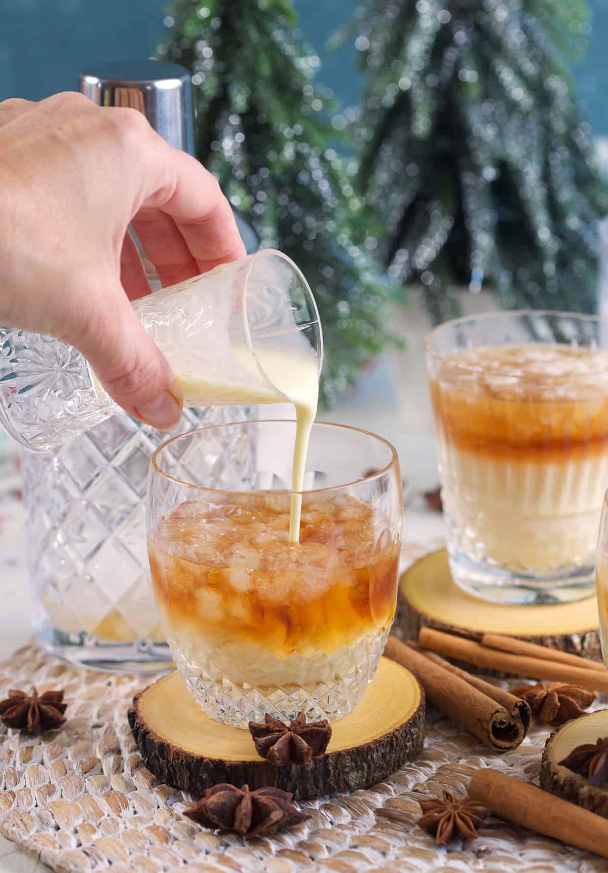 Eggnog is being poured into a glass of white russianingredients. 
