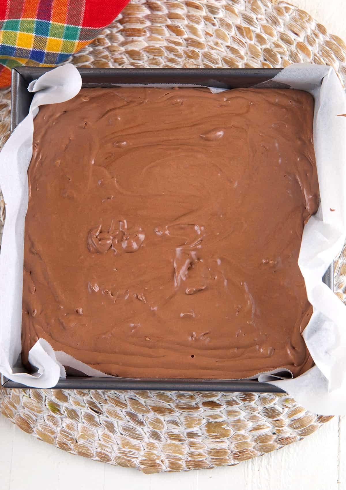 A pan is filled with a liquid fudge mixture that has not yet set.
