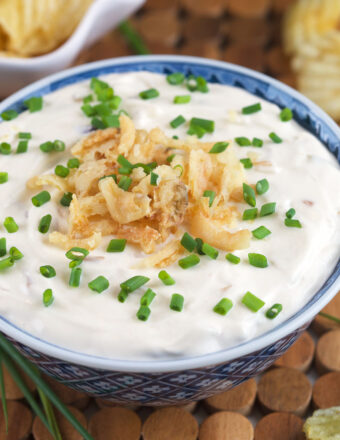 French onion dip is garnished with fried onions and chives.