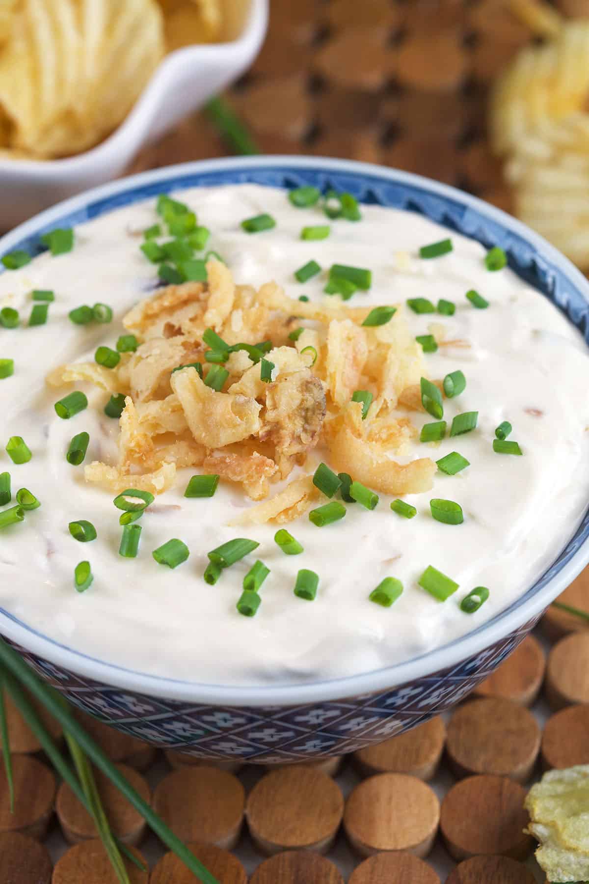 French onion dip is garnished with fried onions and chives. 