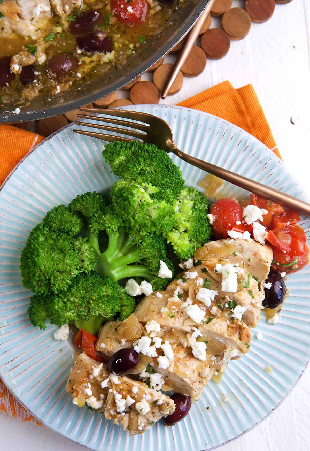 A sliced chicken breast is placed next to cooked broccoli.