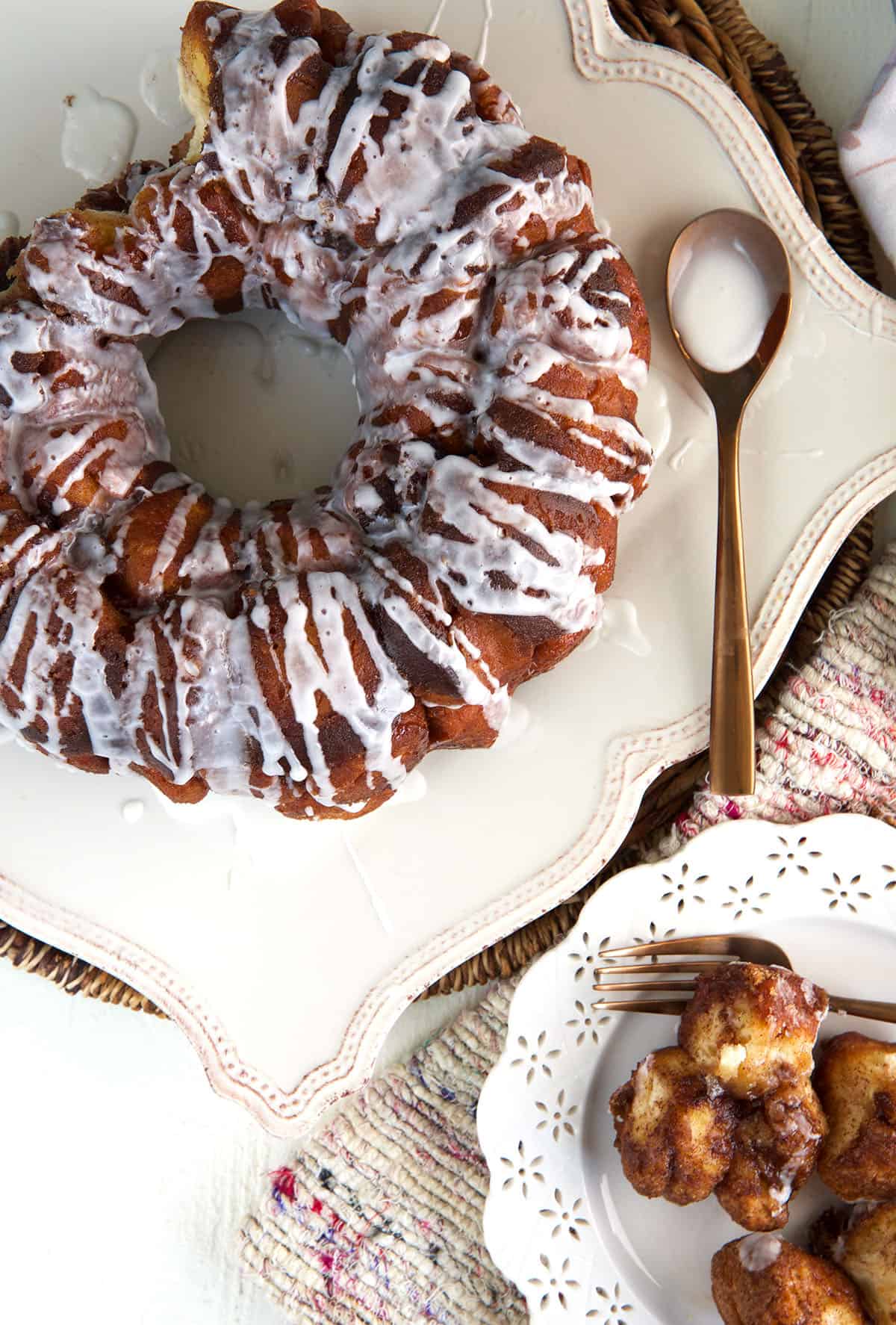 A whole monkey bread is placed next to a plate of smaller bites. 