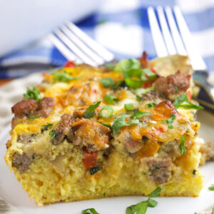A slice of breakfast casserole is garnished with green onions.