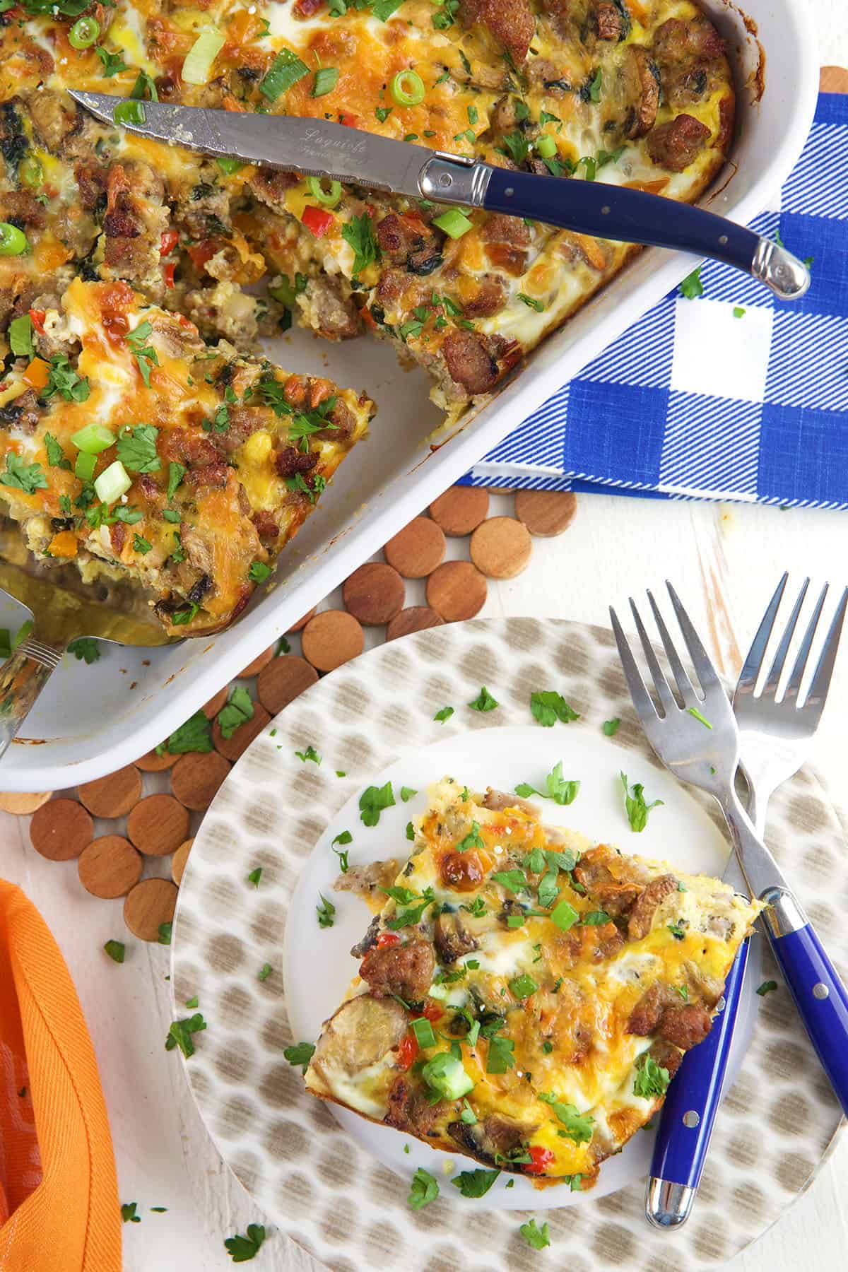 A serving of breakfast casserole is plated next to a whole dish. 