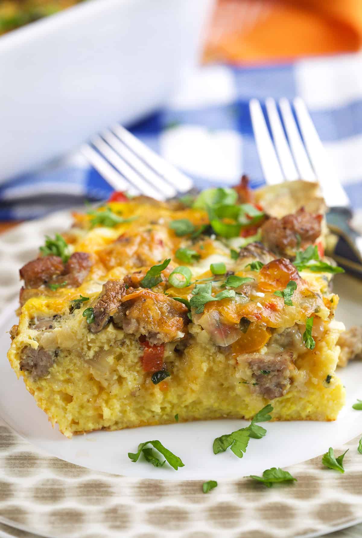 A slice of breakfast casserole is garnished with green onions. 