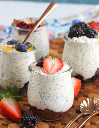 Four small glass jars are filled with overnight oats.