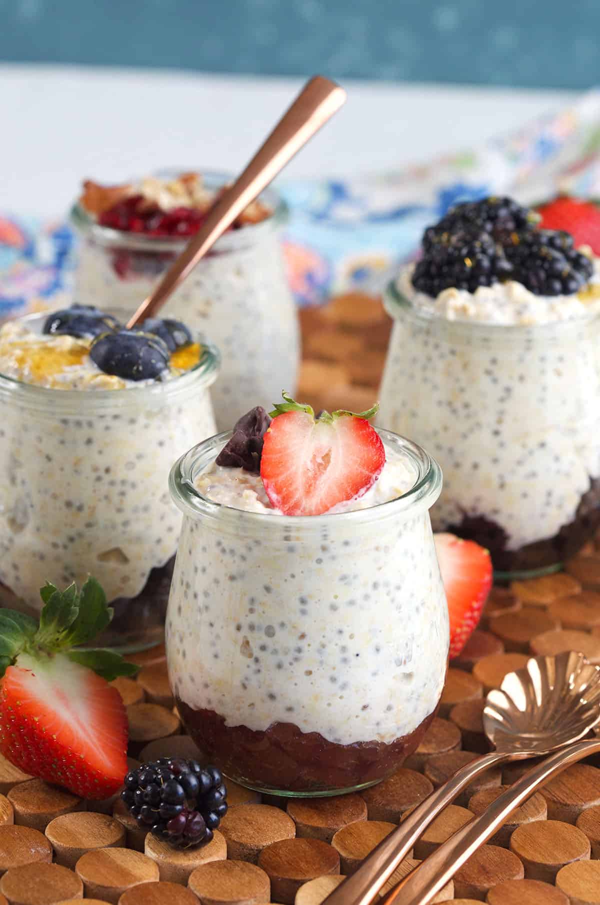 Four small glass jars are filled with overnight oats. 
