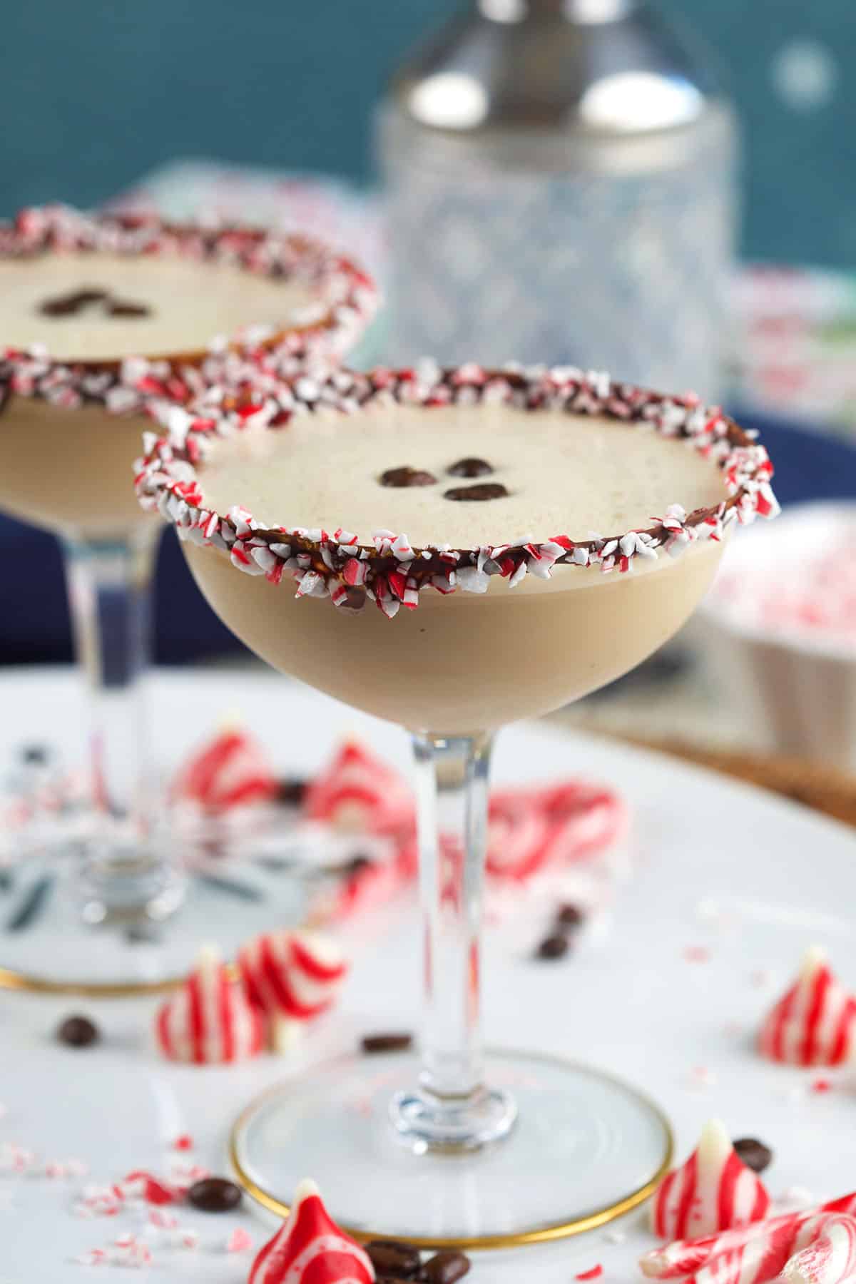 Peppermint candies are scattered around a couple of martini glasses. 