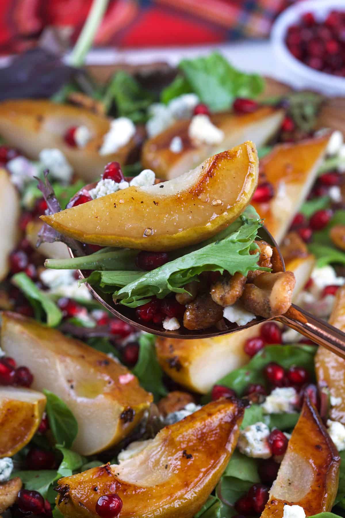 Roasted Pear Salad being served on a copper spoon.