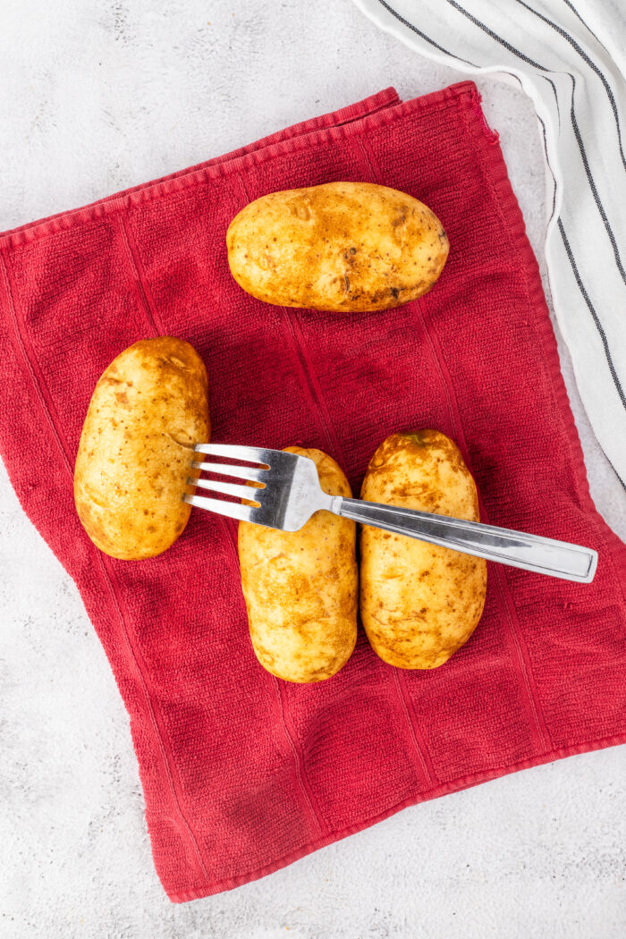 A potato is being pierced with a fork.