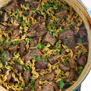 A large pot is filled with beef and noodles.