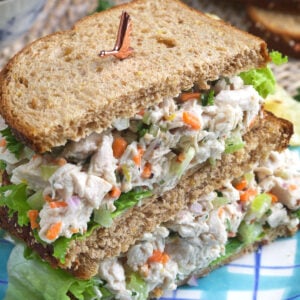 A halved chicken salad sandwich is placed on a plate.