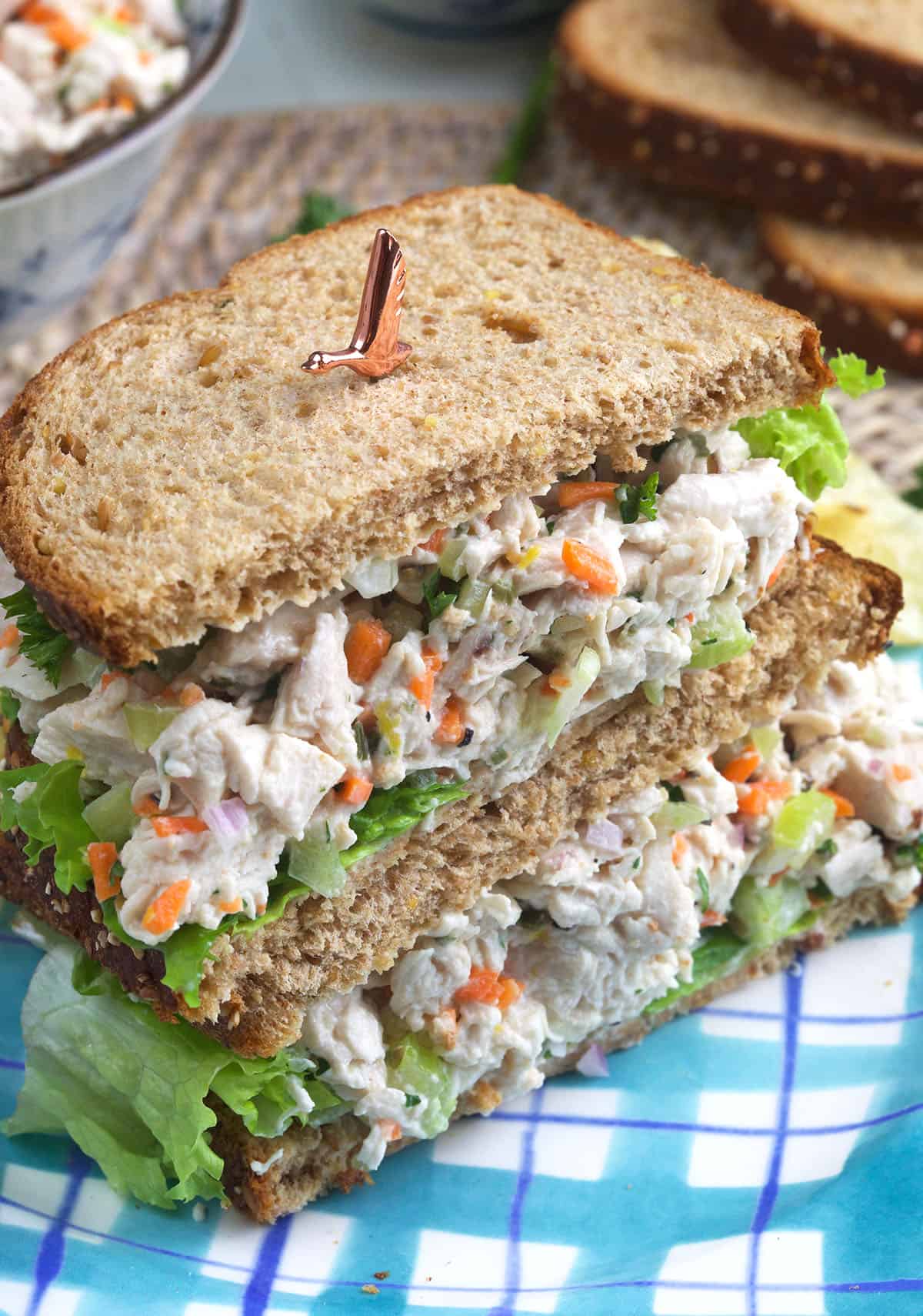 A halved chicken salad sandwich is placed on a plate. 