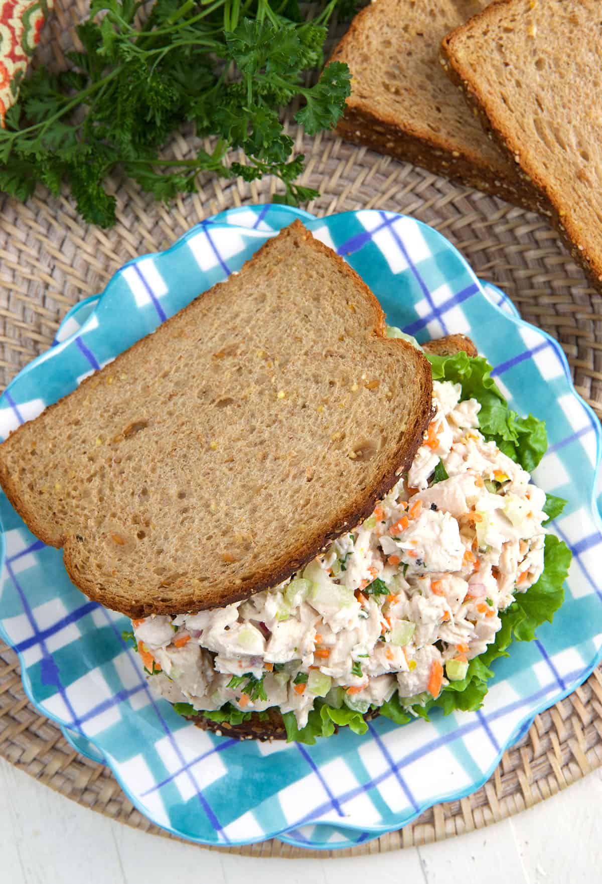 Chicken Salad Sandwich  made with whole wheat bread on a blue plaid plate.