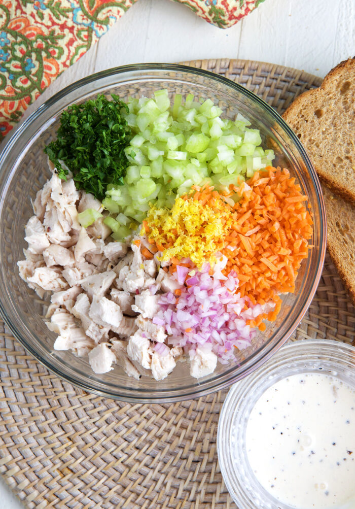 The ingredients for chicken salad are in a glass bowl.