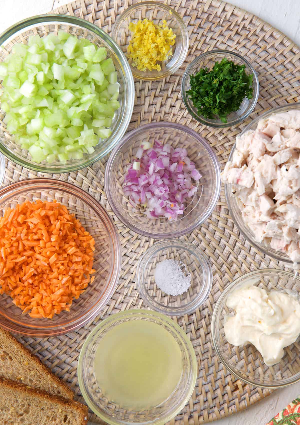 All of the ingredients for chicken salad are placed on a round place mat. 
