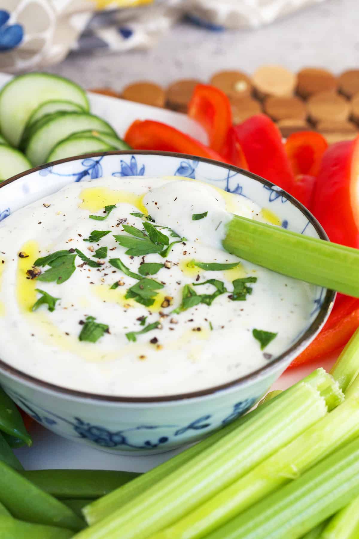 A piece of celery is placed in a bowl of cottage cheese dip. 