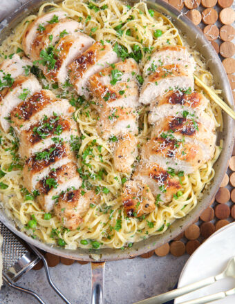 A skillet is filled with garlic parmesan chicken pasta.