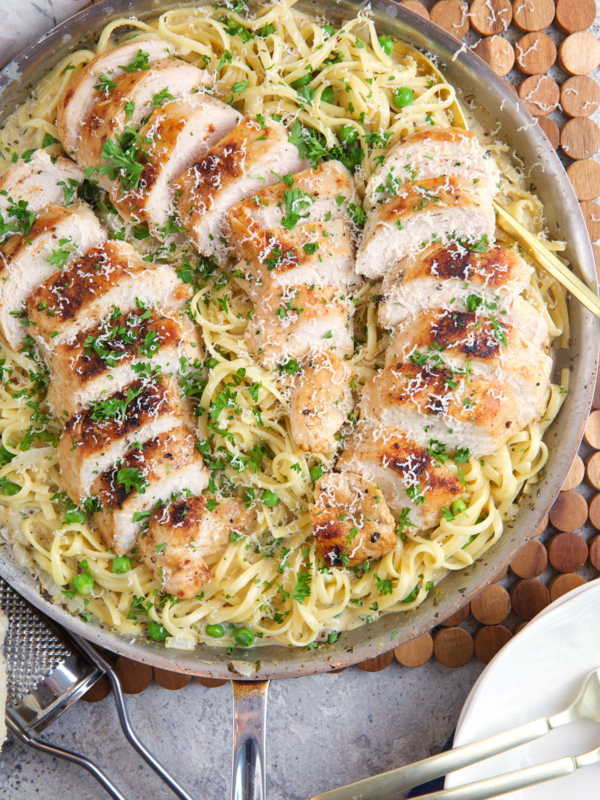 A skillet is filled with garlic parmesan chicken pasta.