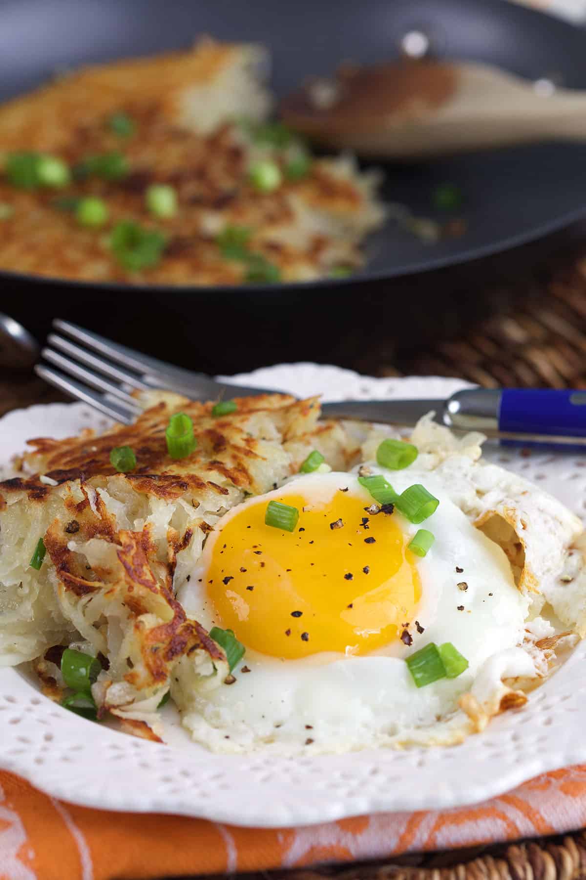 A fried egg is plated with hash browns. 