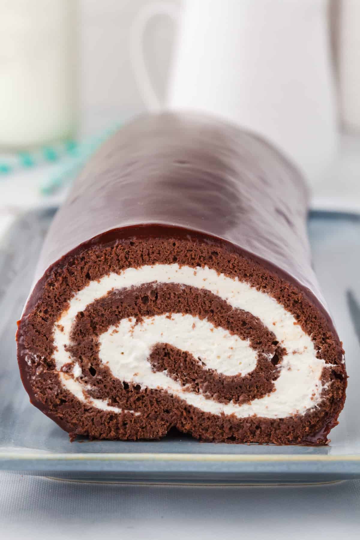 A chocolate swiss roll is presented with a perfect swirl in the center. 