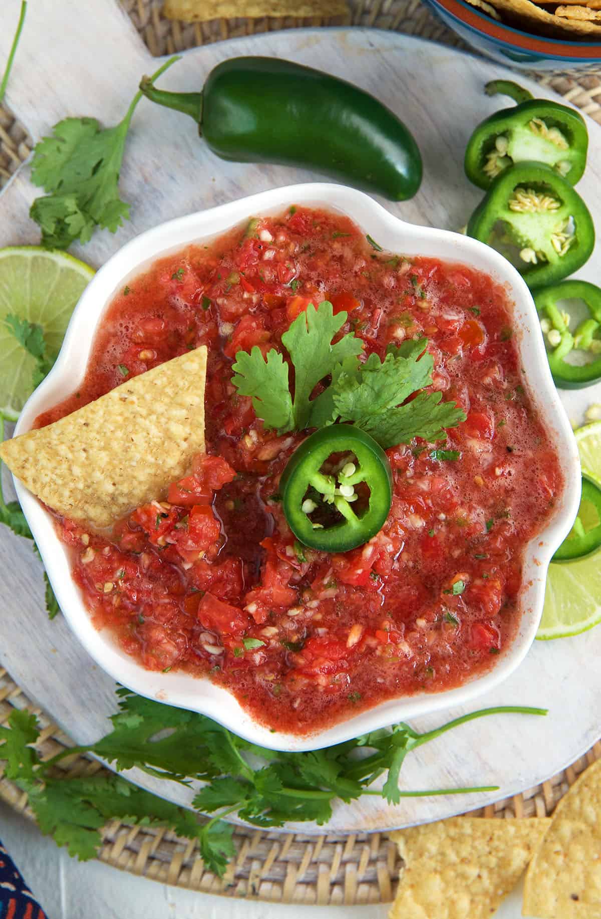 A chip is placed in a bowl full of salsa. 