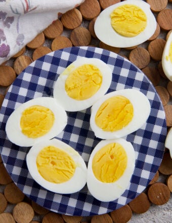 Several sliced hard boiled eggs are on a blue and white plate.
