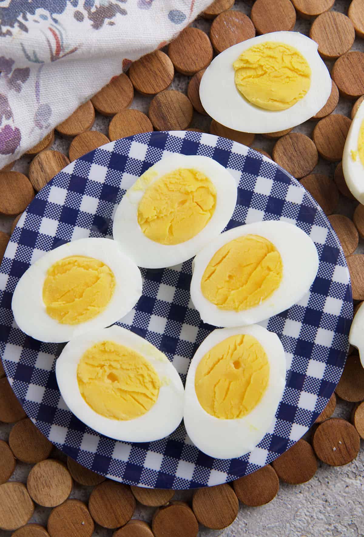 Several sliced hard boiled eggs are on a blue and white plate. 